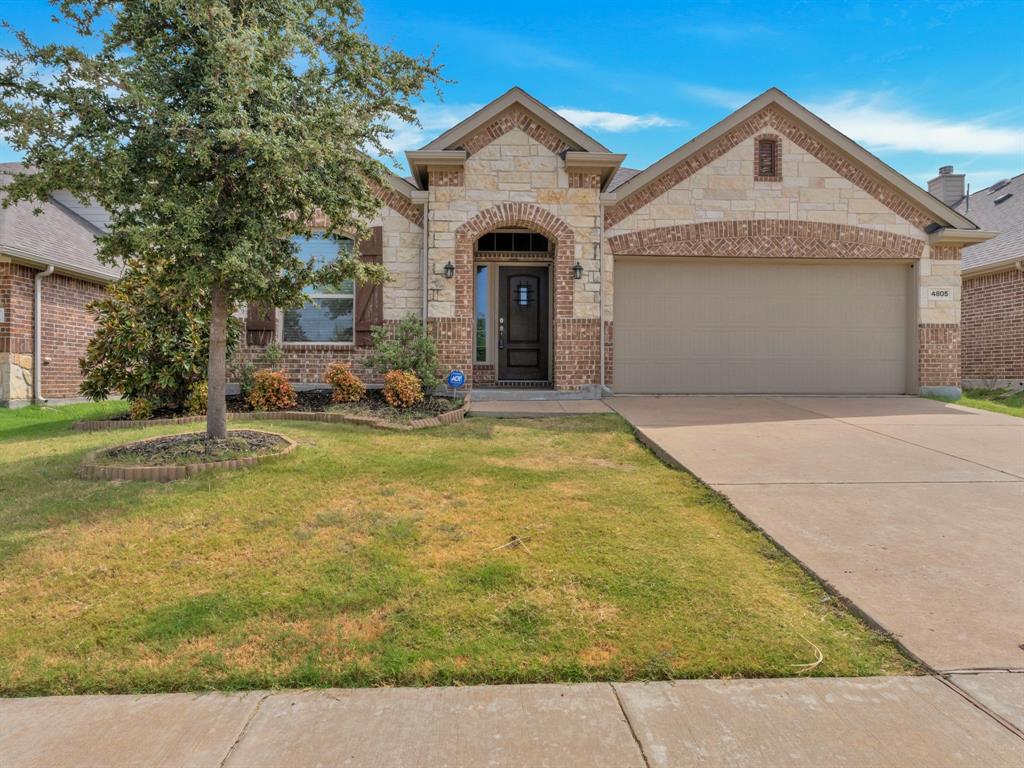 a front view of a house with yard and garage