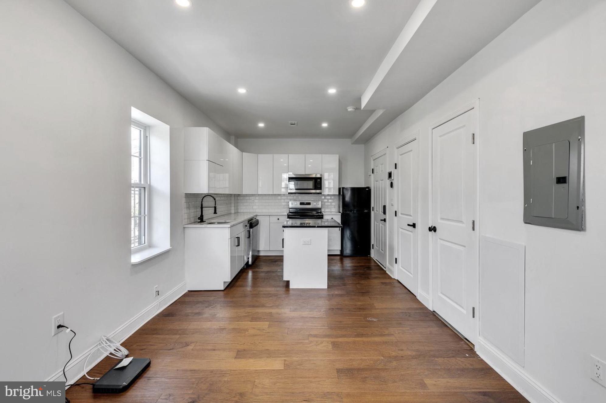 a kitchen with white cabinets and stainless steel appliances