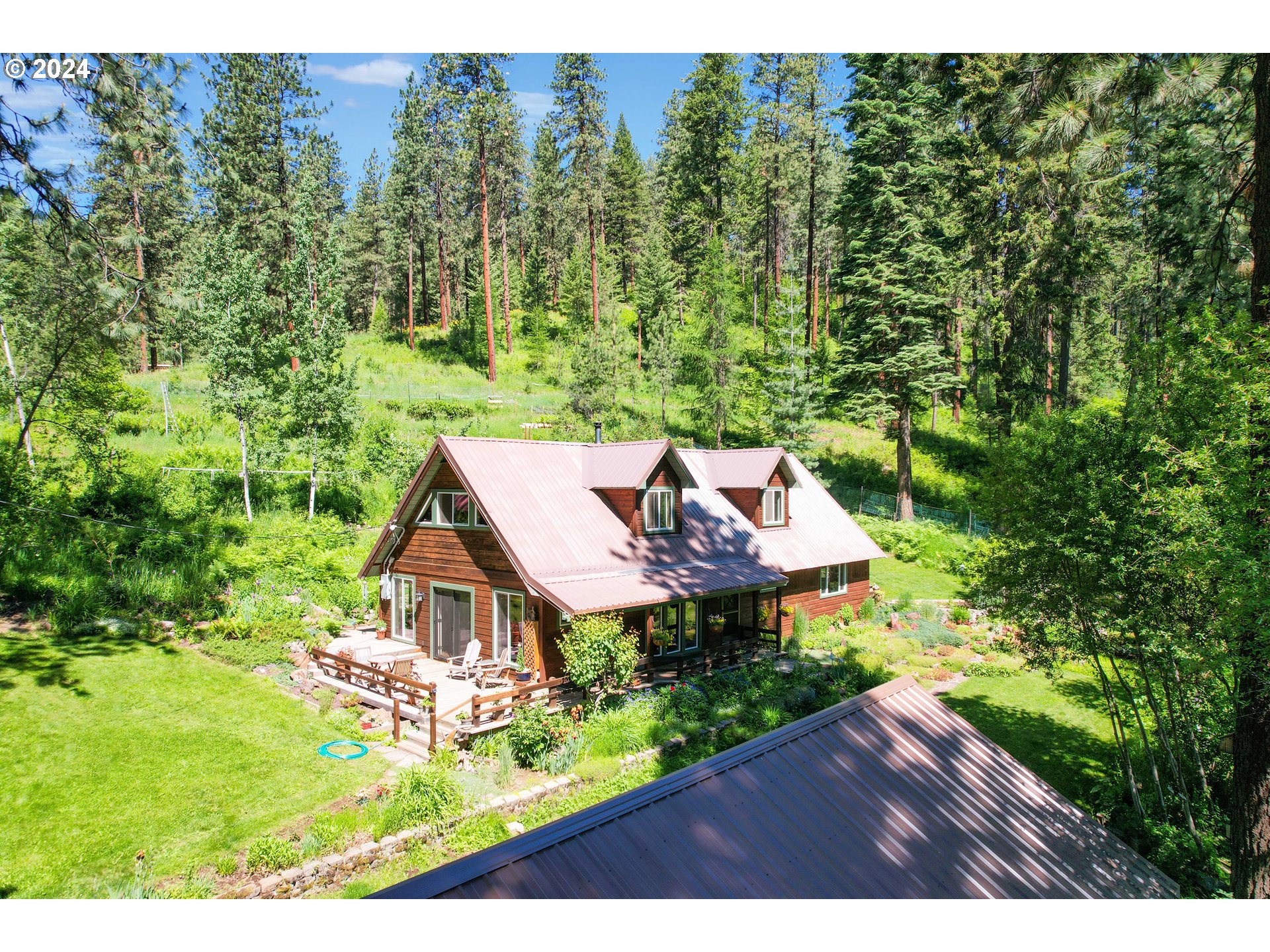 an aerial view of a house with yard and green space