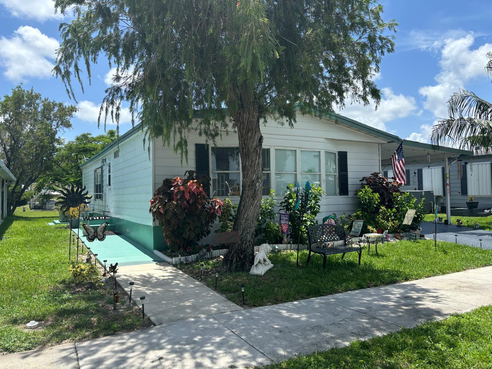 a front view of a house with a yard and a garden