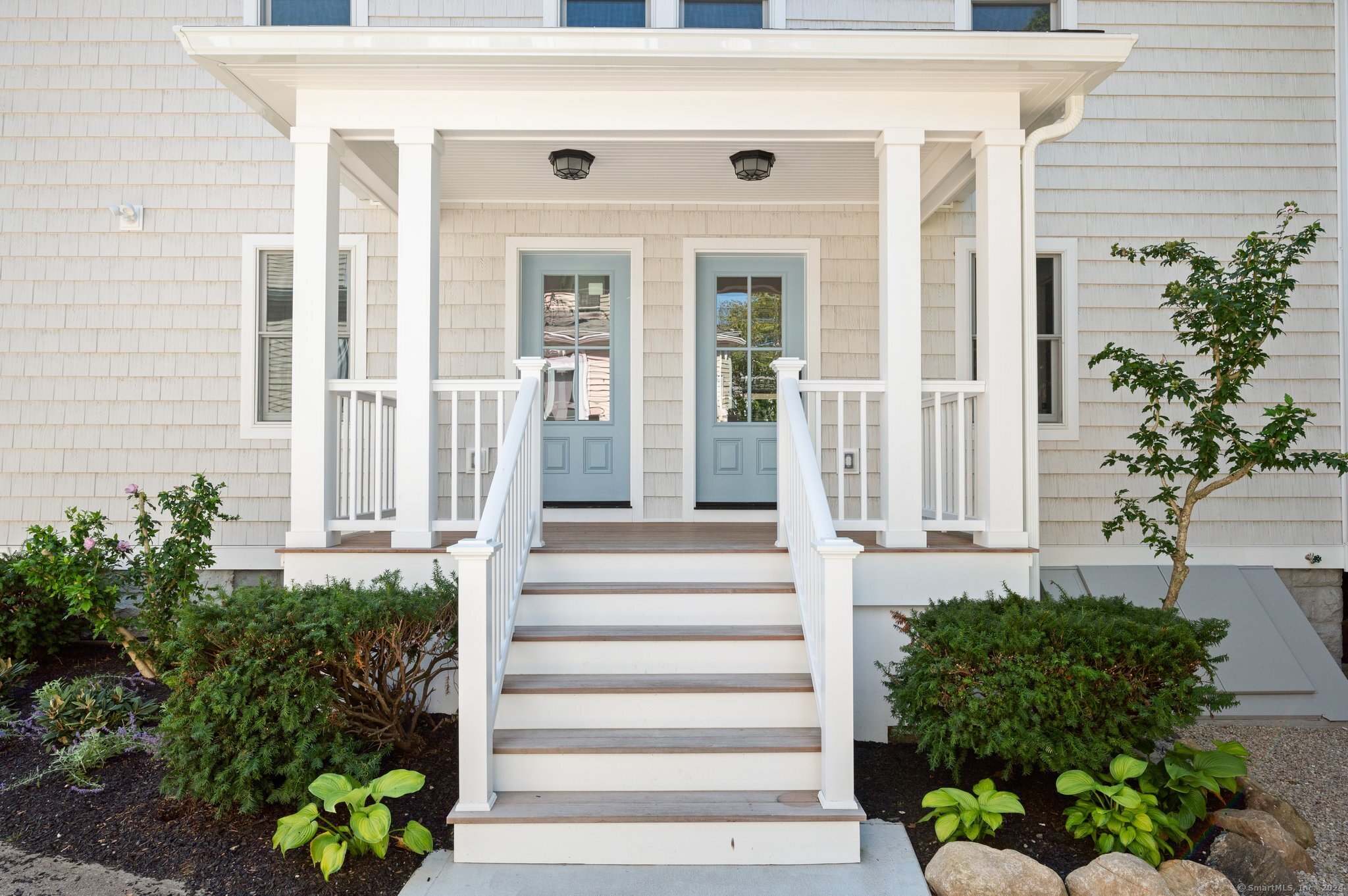 a front view of a house with plants