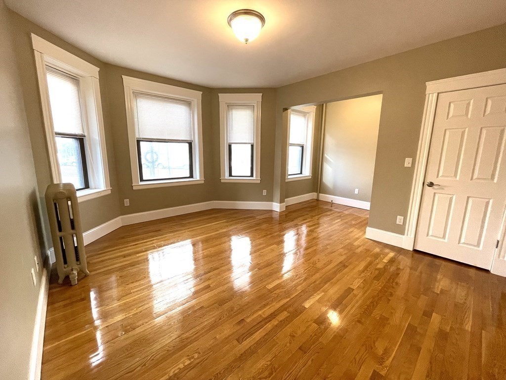 a view of a livingroom with wooden floor and a window