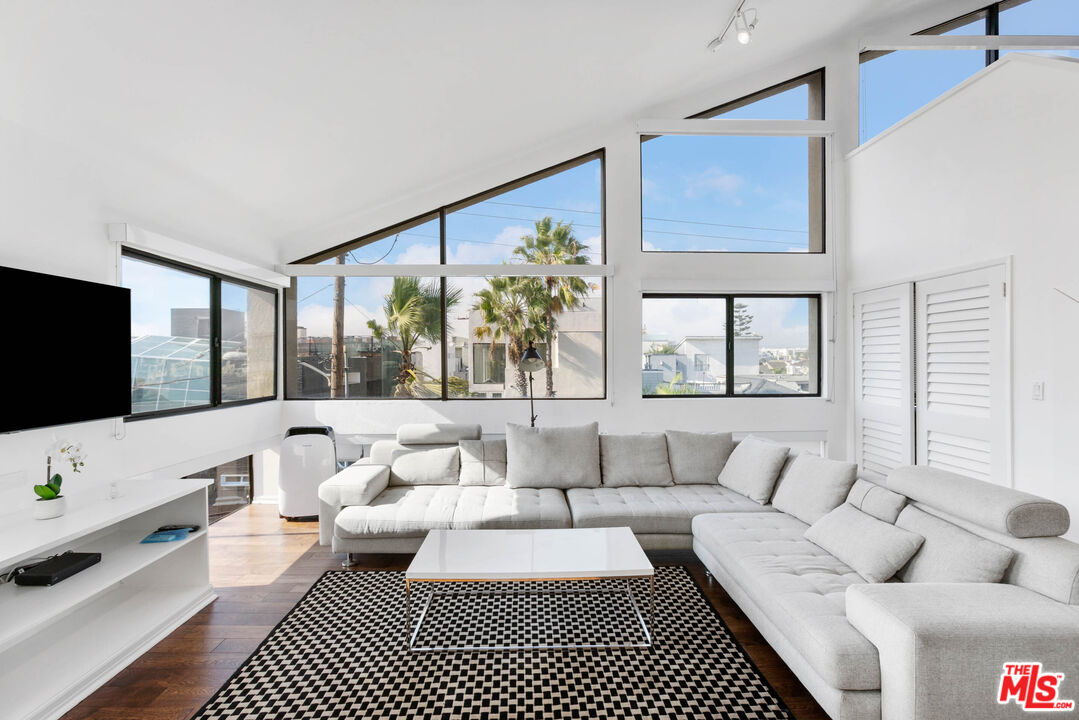 a living room with furniture a flat screen tv and a large window