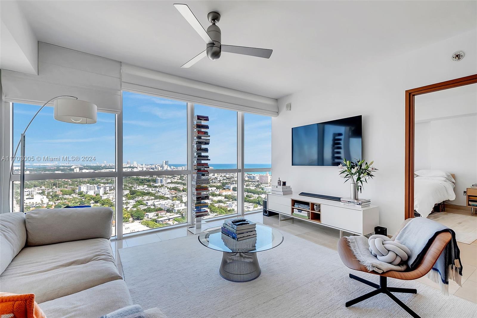 a living room with furniture and a floor to ceiling window