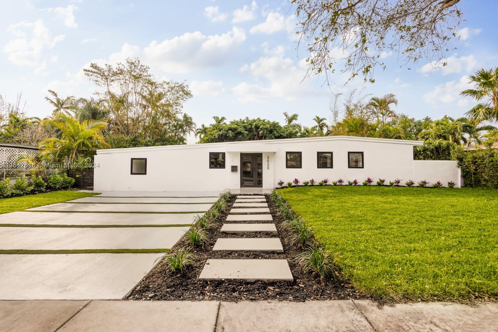 a front view of a house with a garden