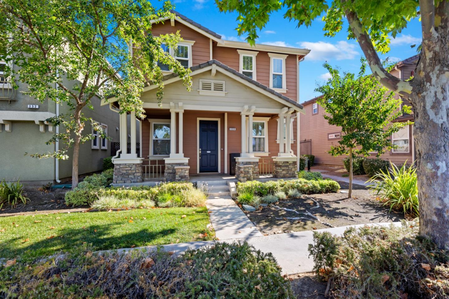 a front view of a house with a yard and potted plants