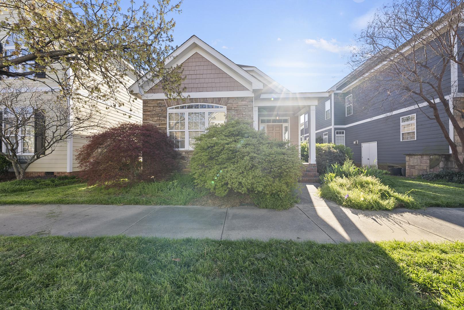 a front view of a house with a yard and potted plants