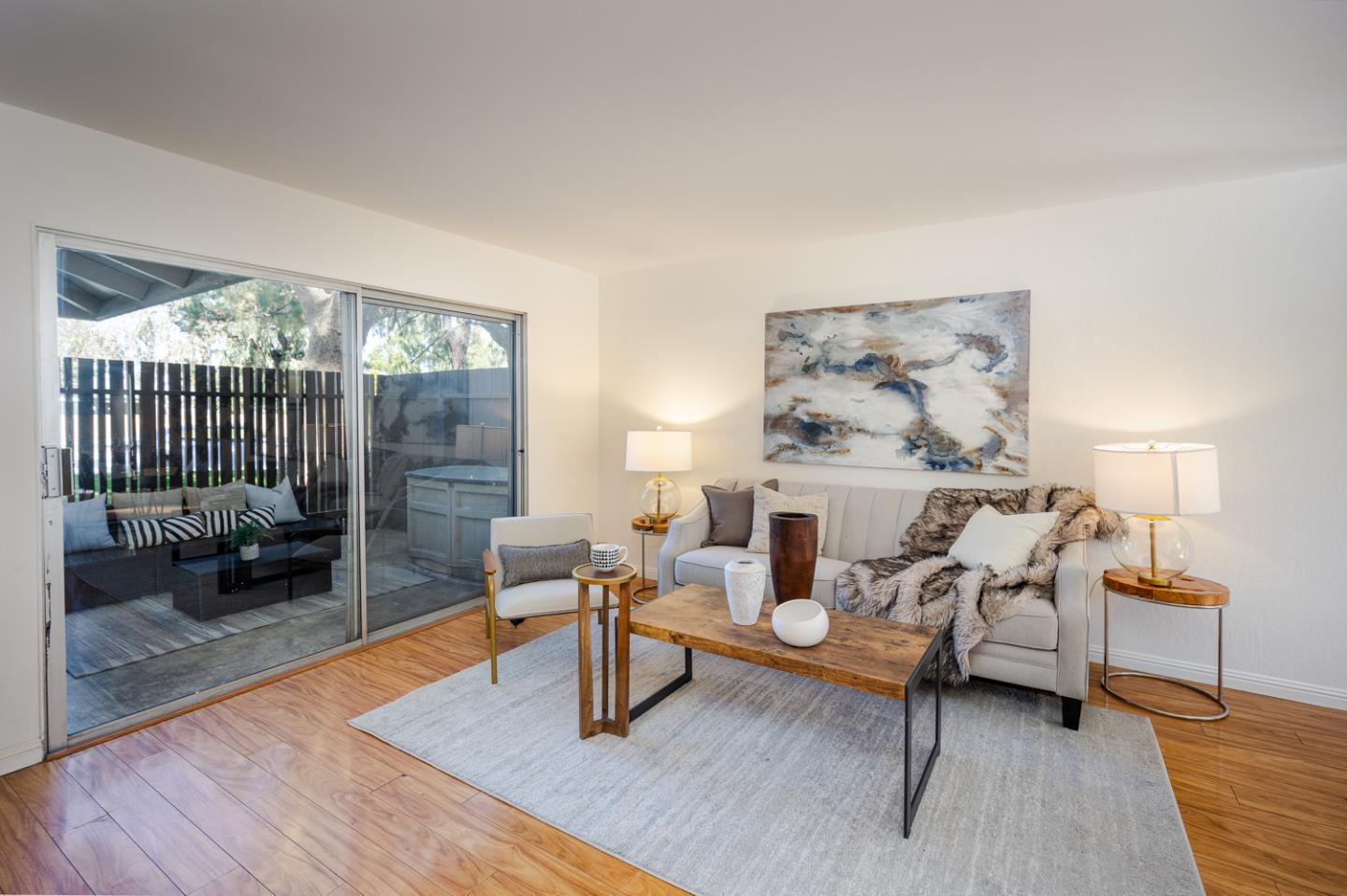 a living room with furniture a rug and a floor to ceiling window