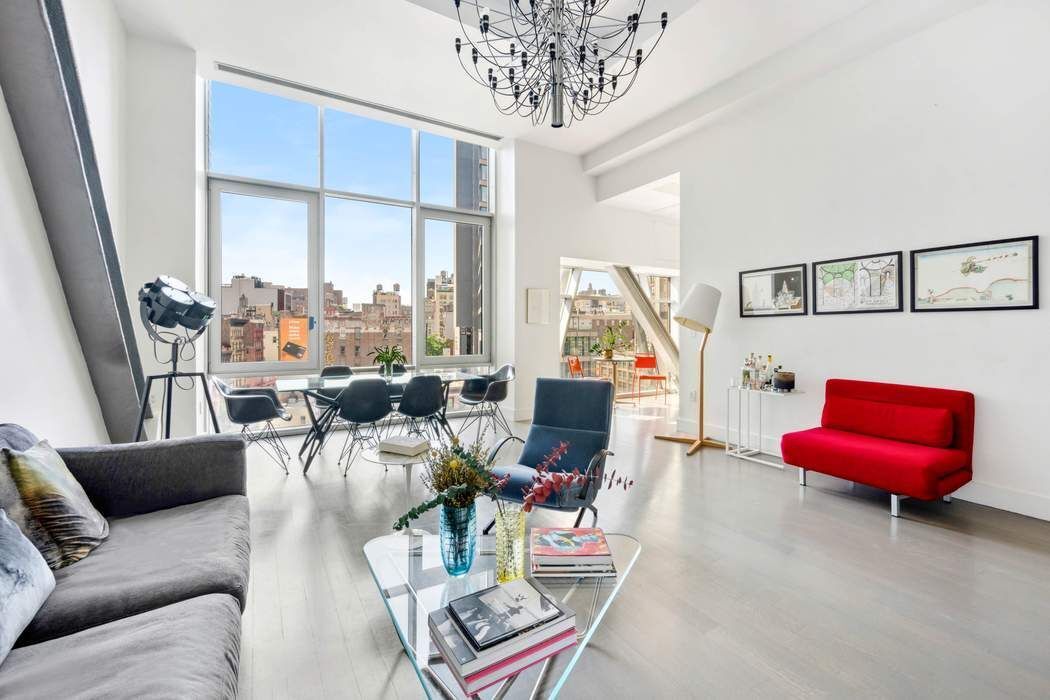 a living room with furniture a rug and a floor to ceiling window