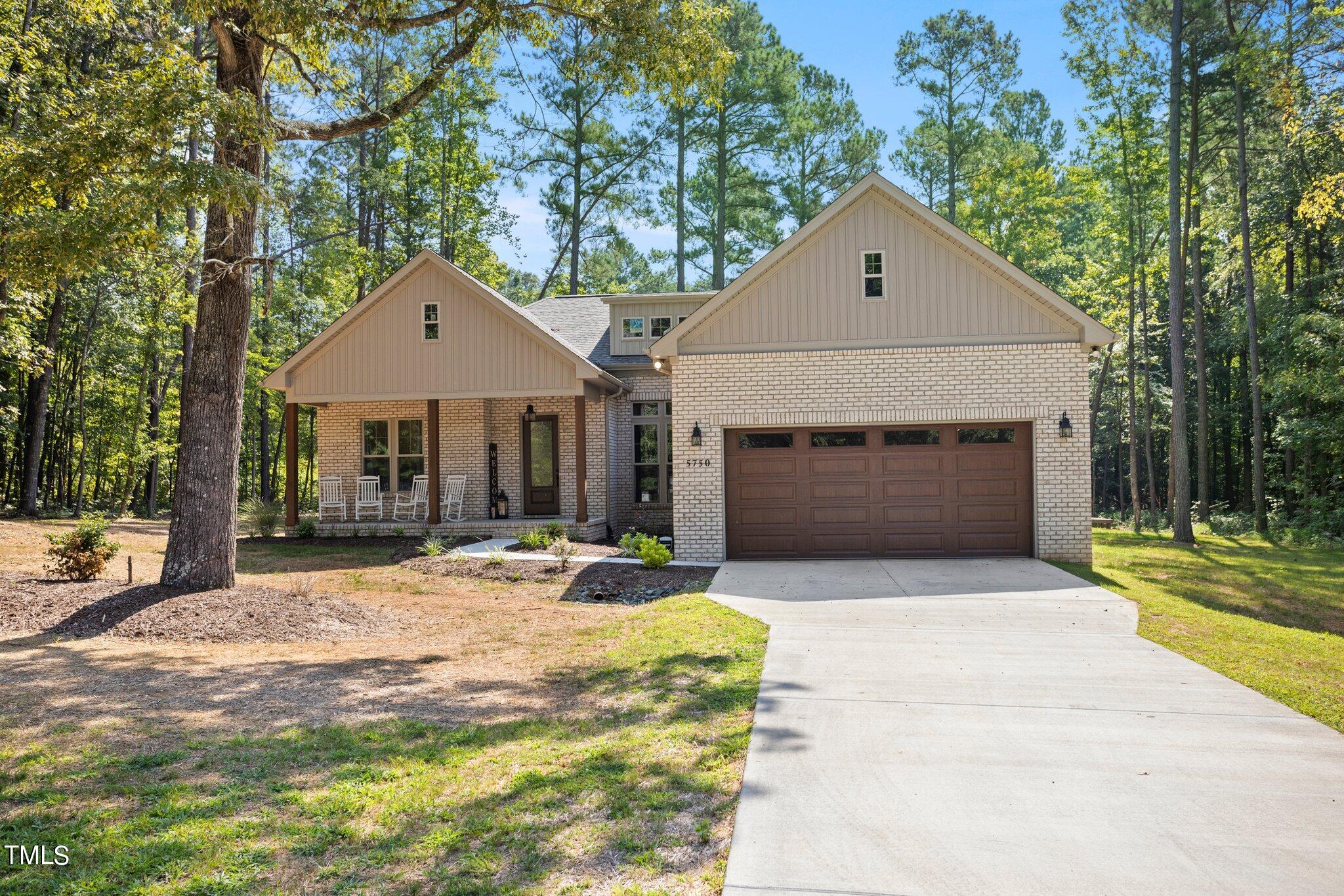 a front view of a house with a garden and yard