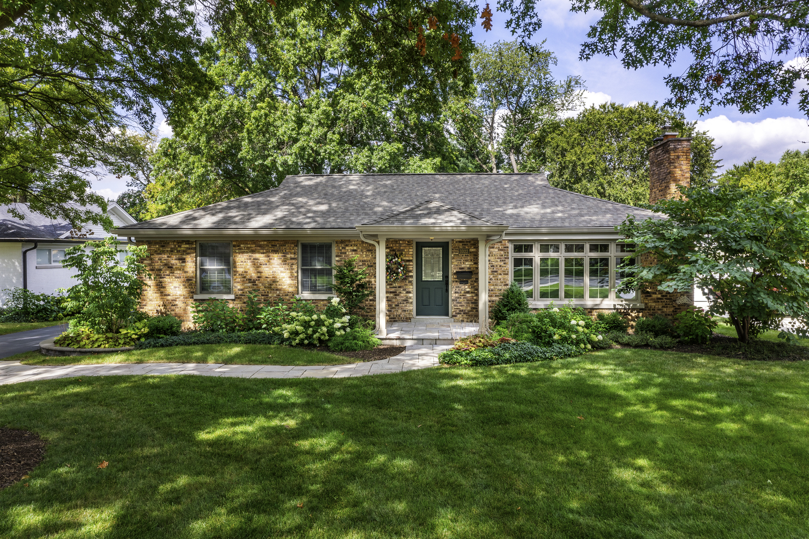 a front view of a house with a yard and green space