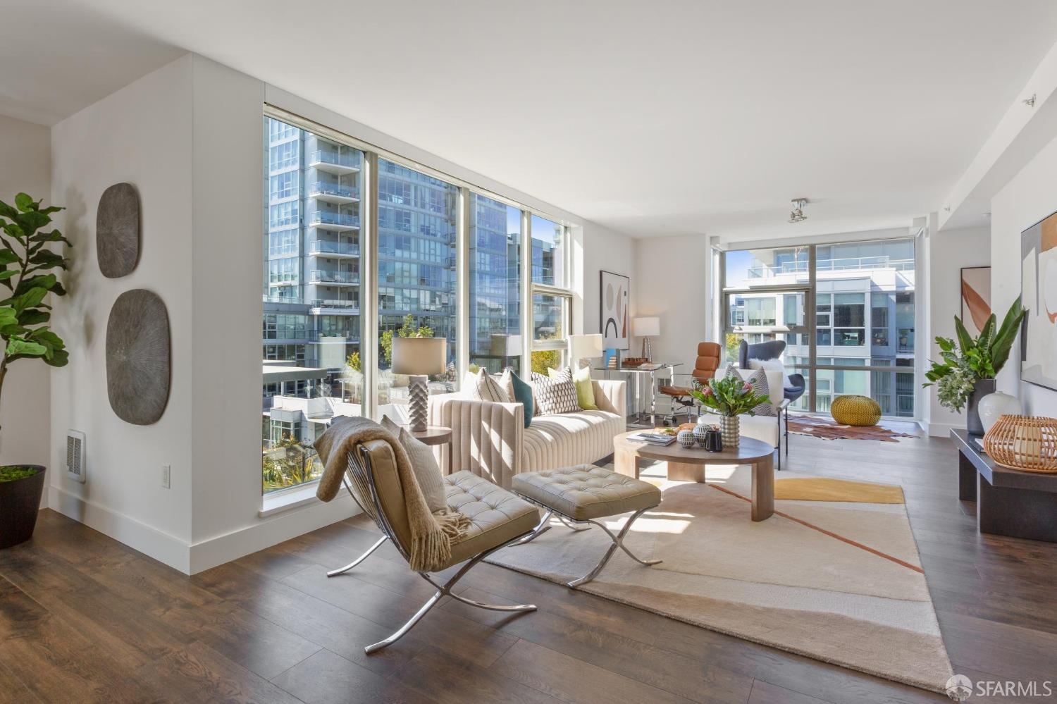 a living room with furniture potted plant and large windows