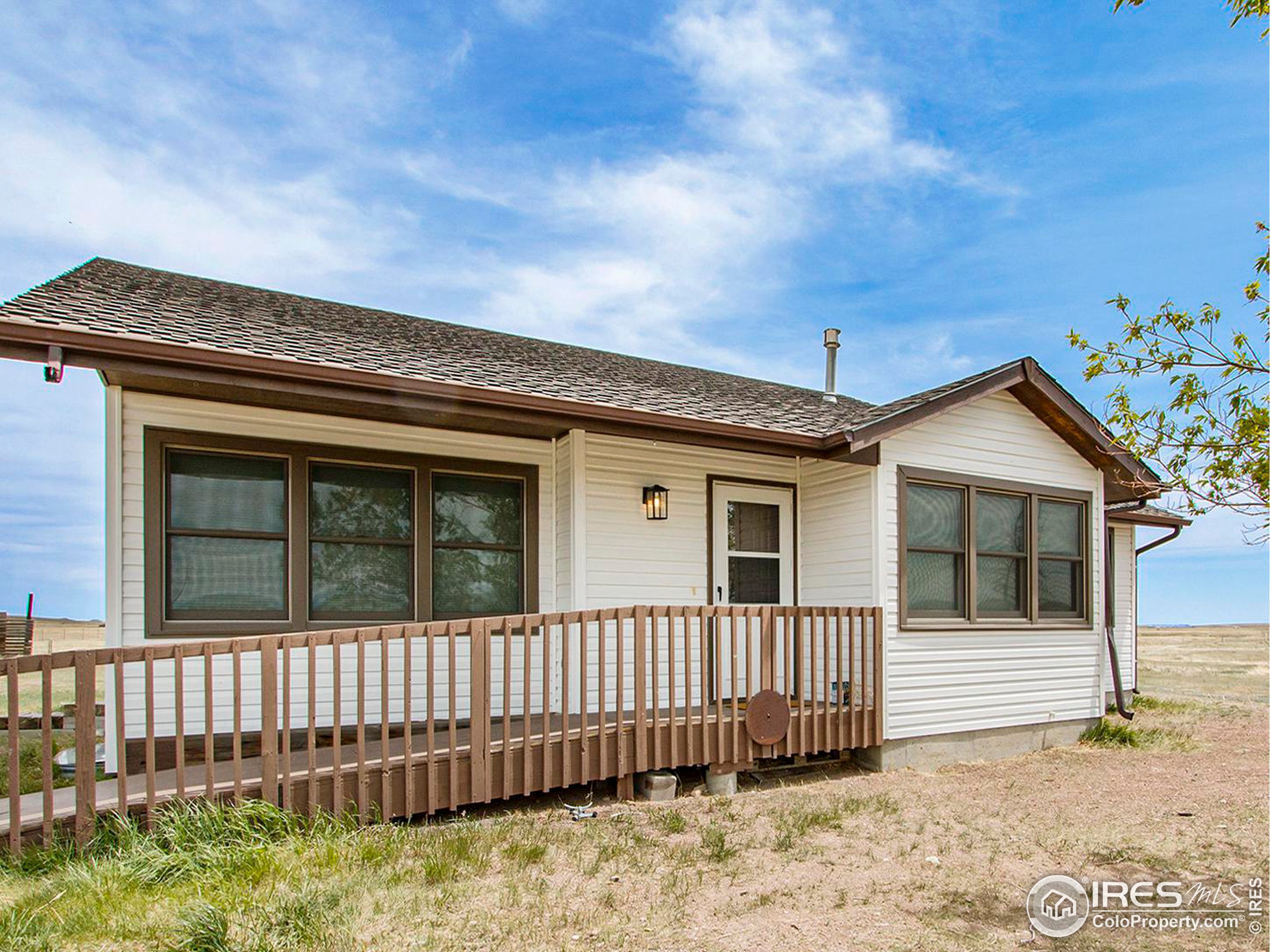 a view of a house with a small yard and wooden fence