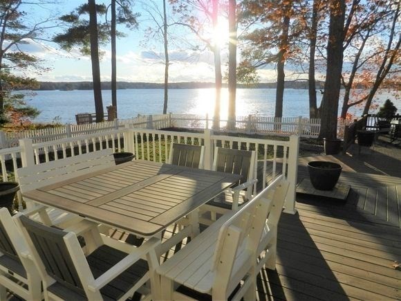 a view of a balcony with wooden floor and outdoor seating