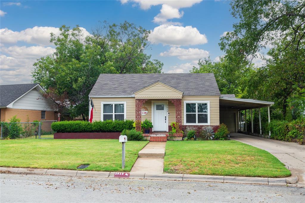 a front view of a house with a yard and potted plants