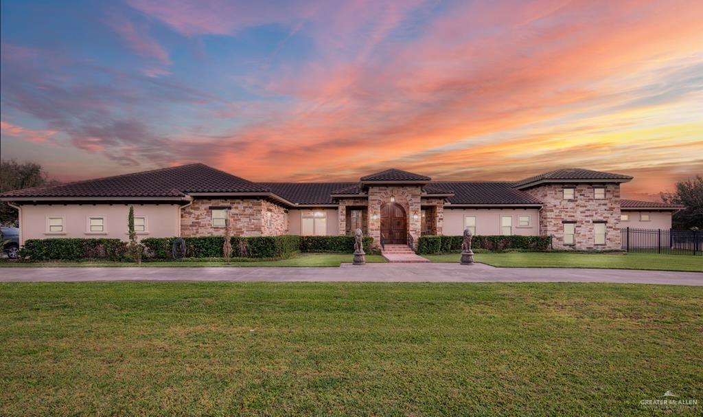 The main house is expansive and regal with a manicured lawn.