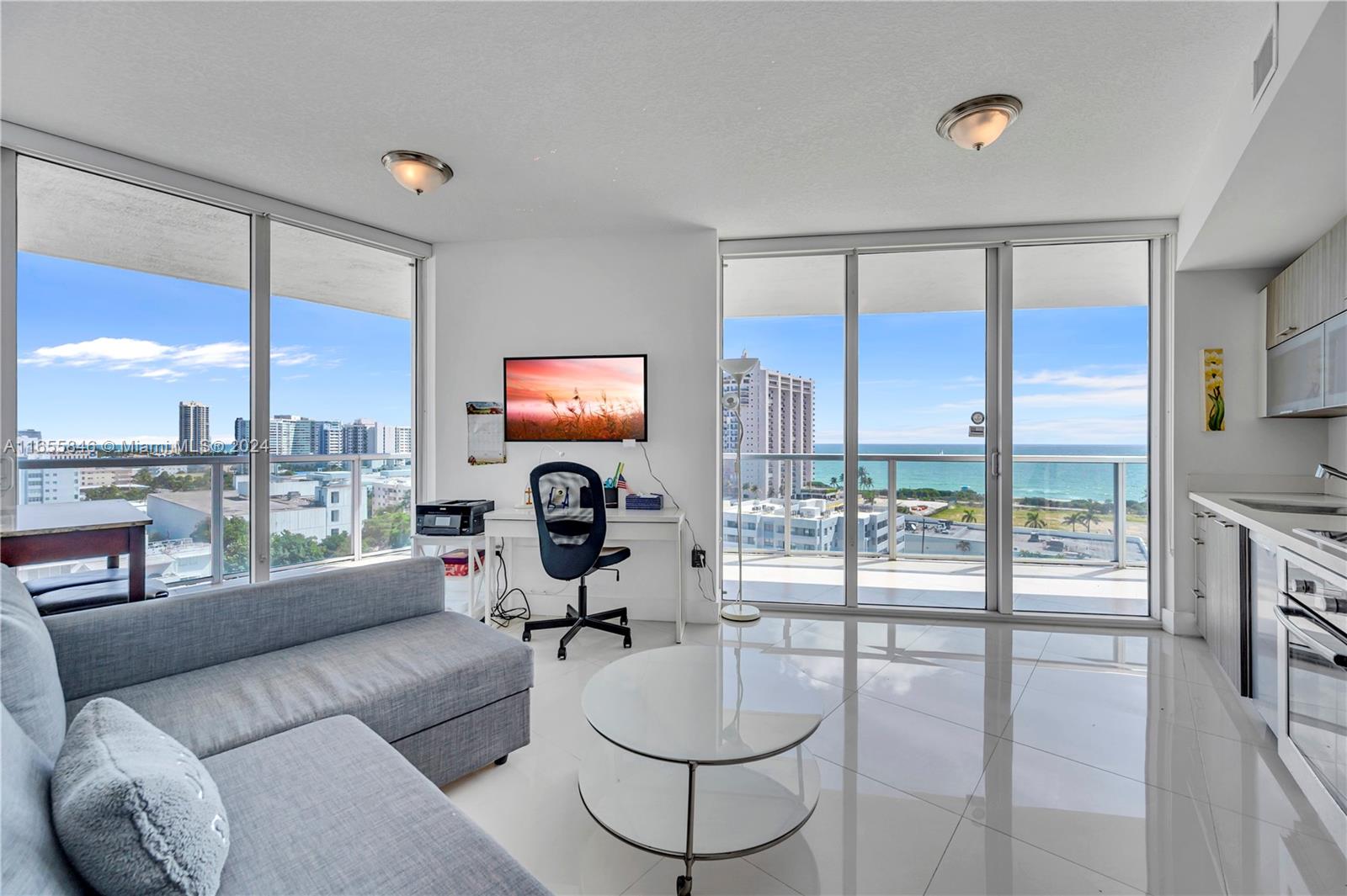 a living room with furniture a floor to ceiling window and a flat screen tv