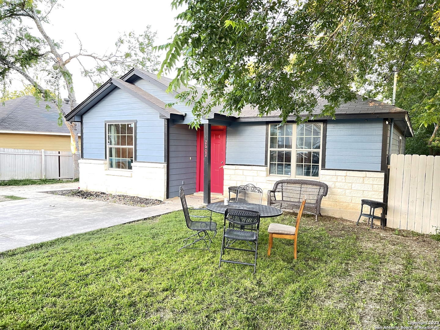 a backyard of a house with table and chairs