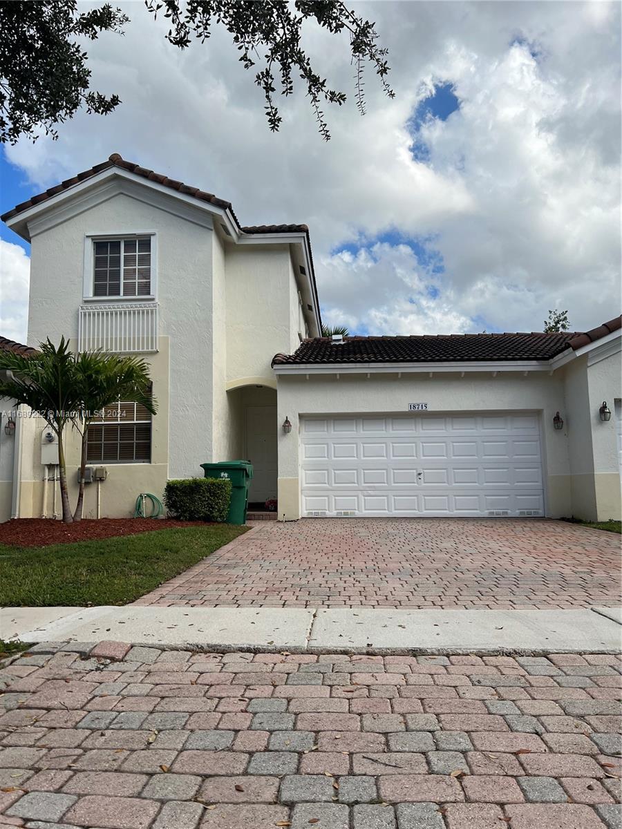 a front view of a house with a yard and garage