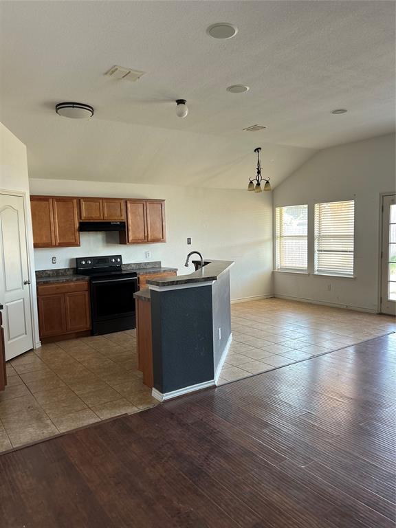 a kitchen with stainless steel appliances granite countertop a stove a sink and a microwave