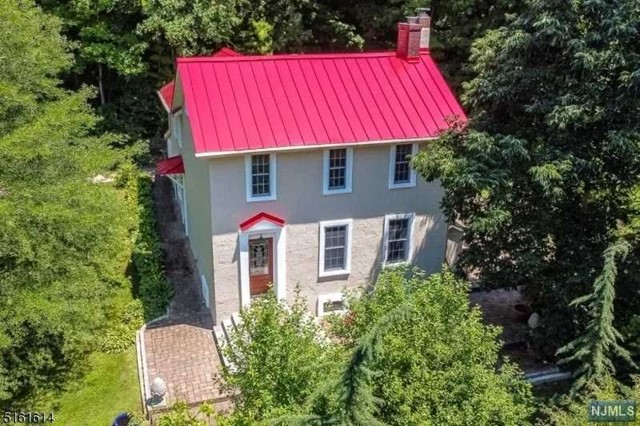 an aerial view of a house with swimming pool and red umbrella