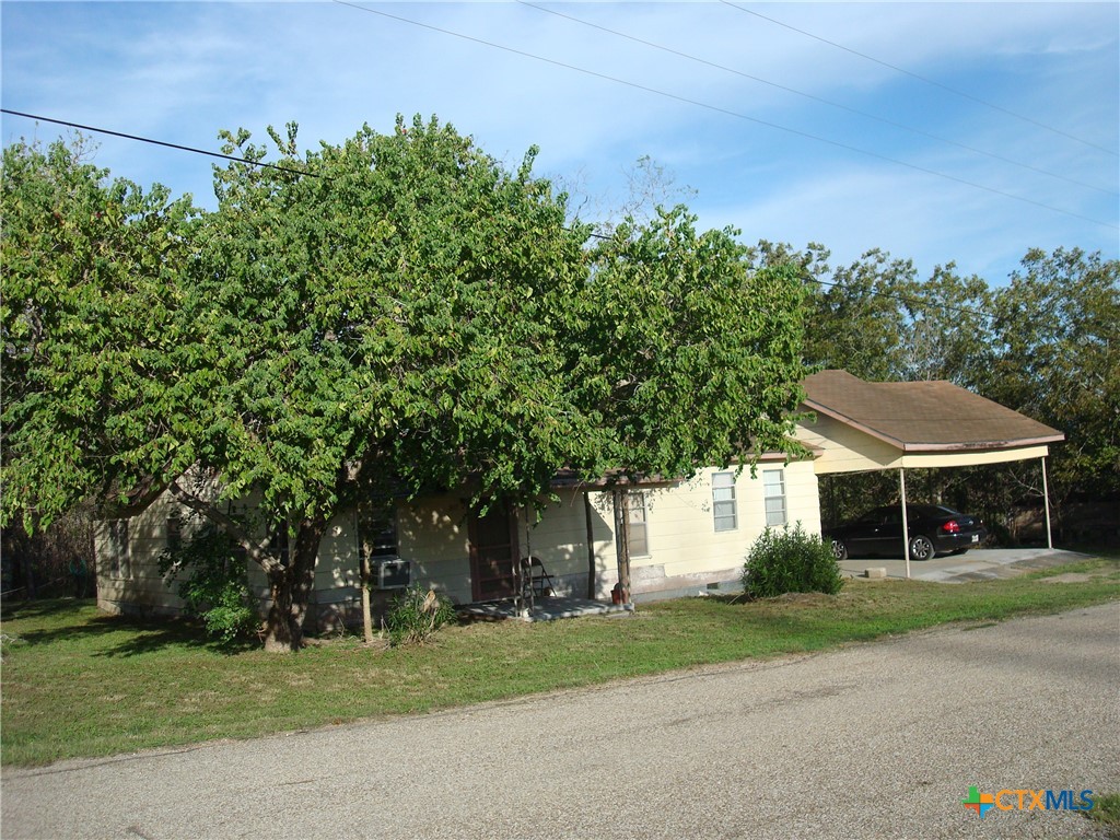 a front view of a house with a yard and trees