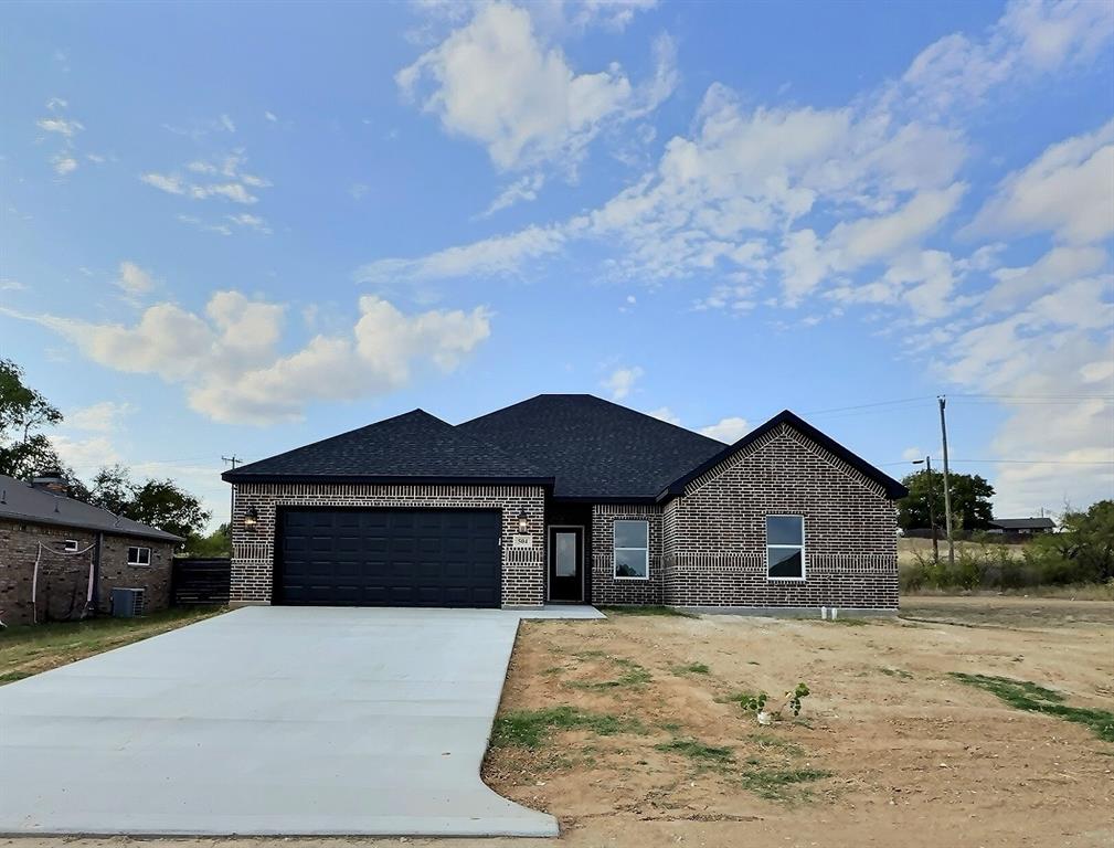 View of front facade featuring a garage and central AC unit