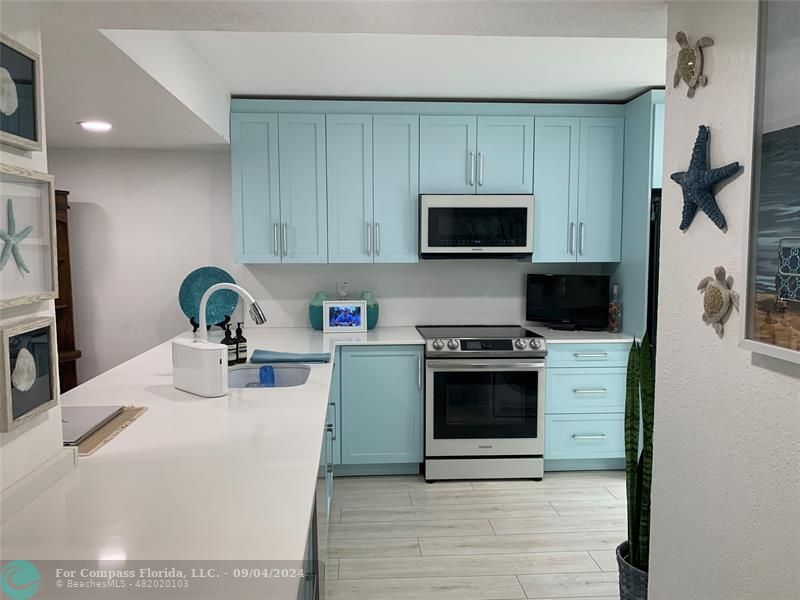 a kitchen with a microwave stove top oven and sink