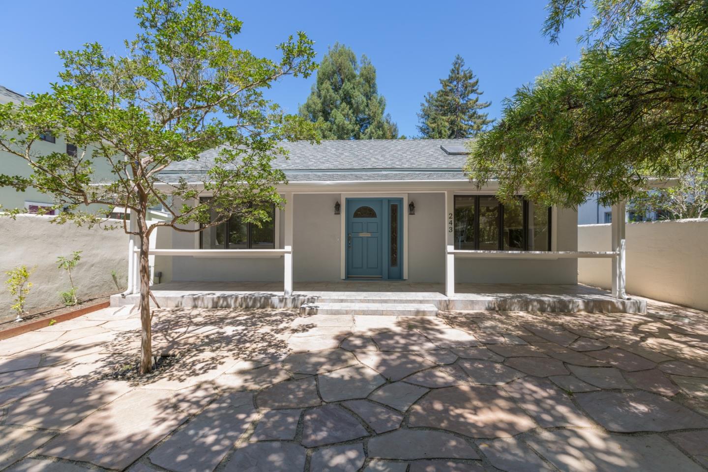 a view of a house with a tree in front of it