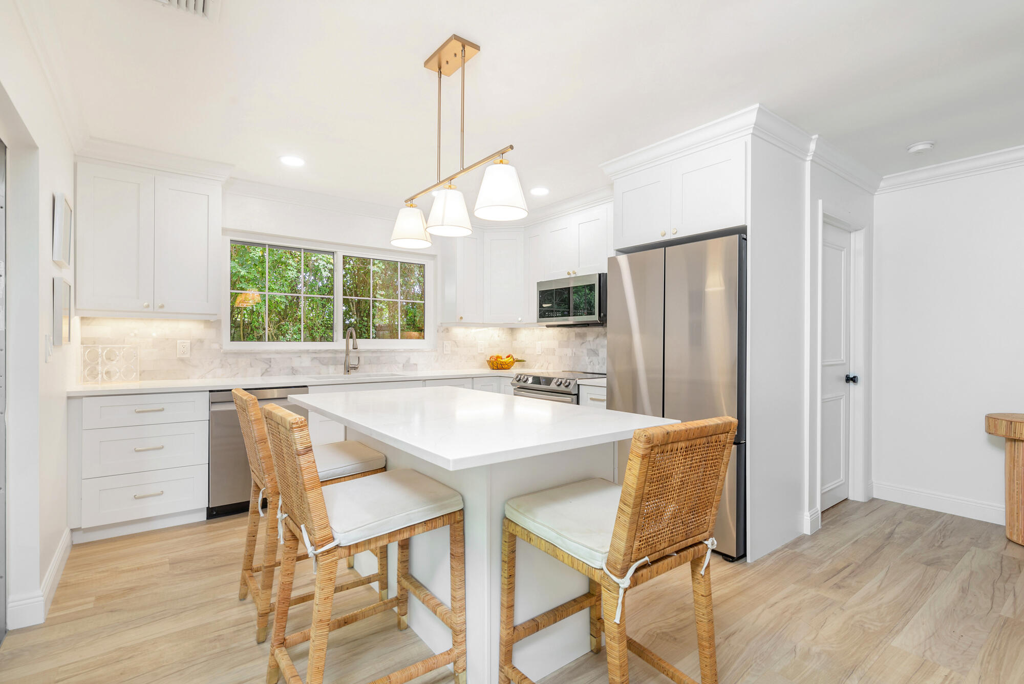 a kitchen with stainless steel appliances a dining table chairs and chandelier