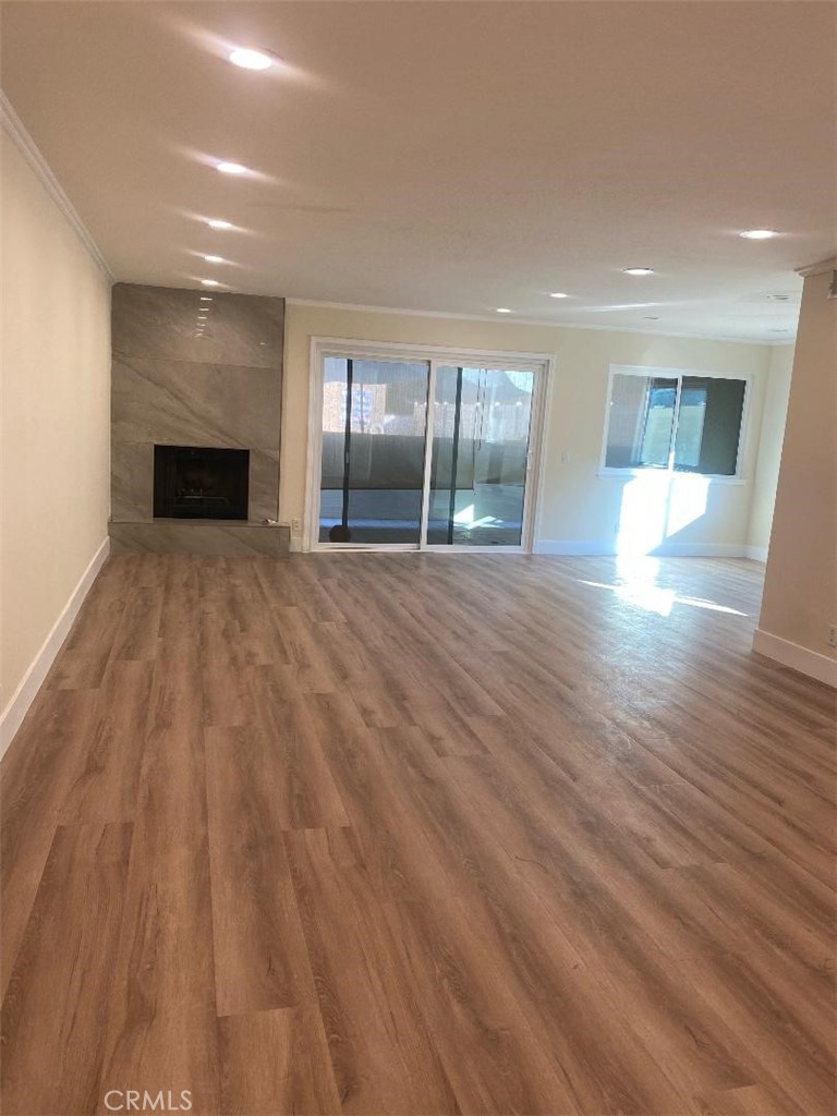 an empty room with wooden floor and fireplace