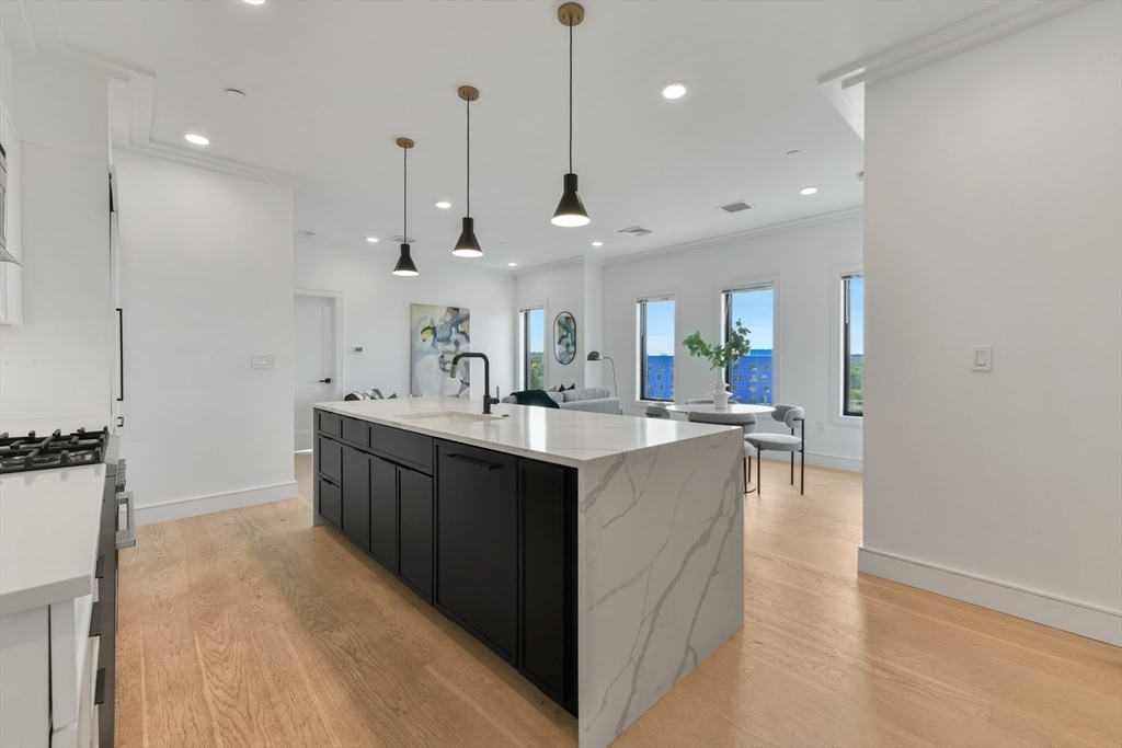 a large kitchen with kitchen island a sink a center island a stove and a cabinets