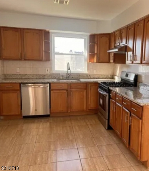 a kitchen with stainless steel appliances granite countertop a stove sink and cabinets