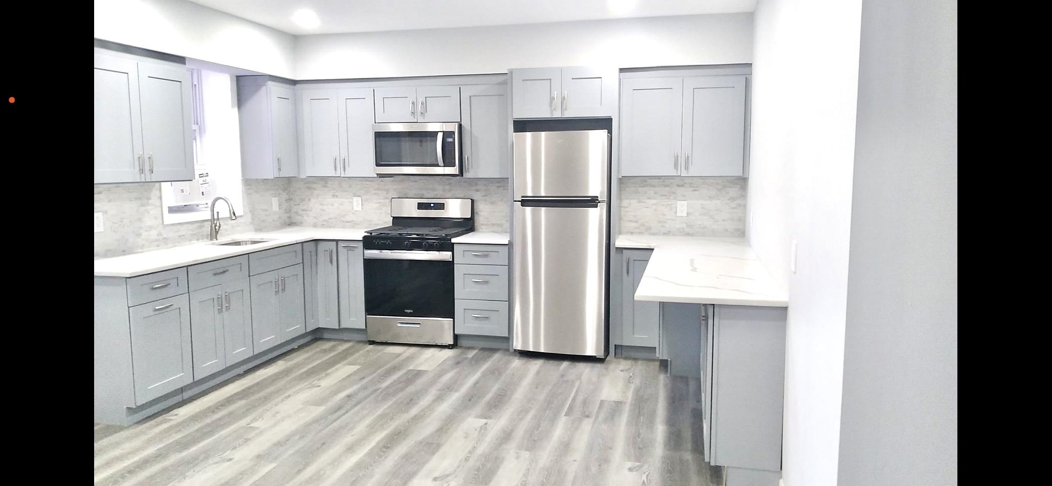 a kitchen with a sink cabinets stainless steel appliances and a window