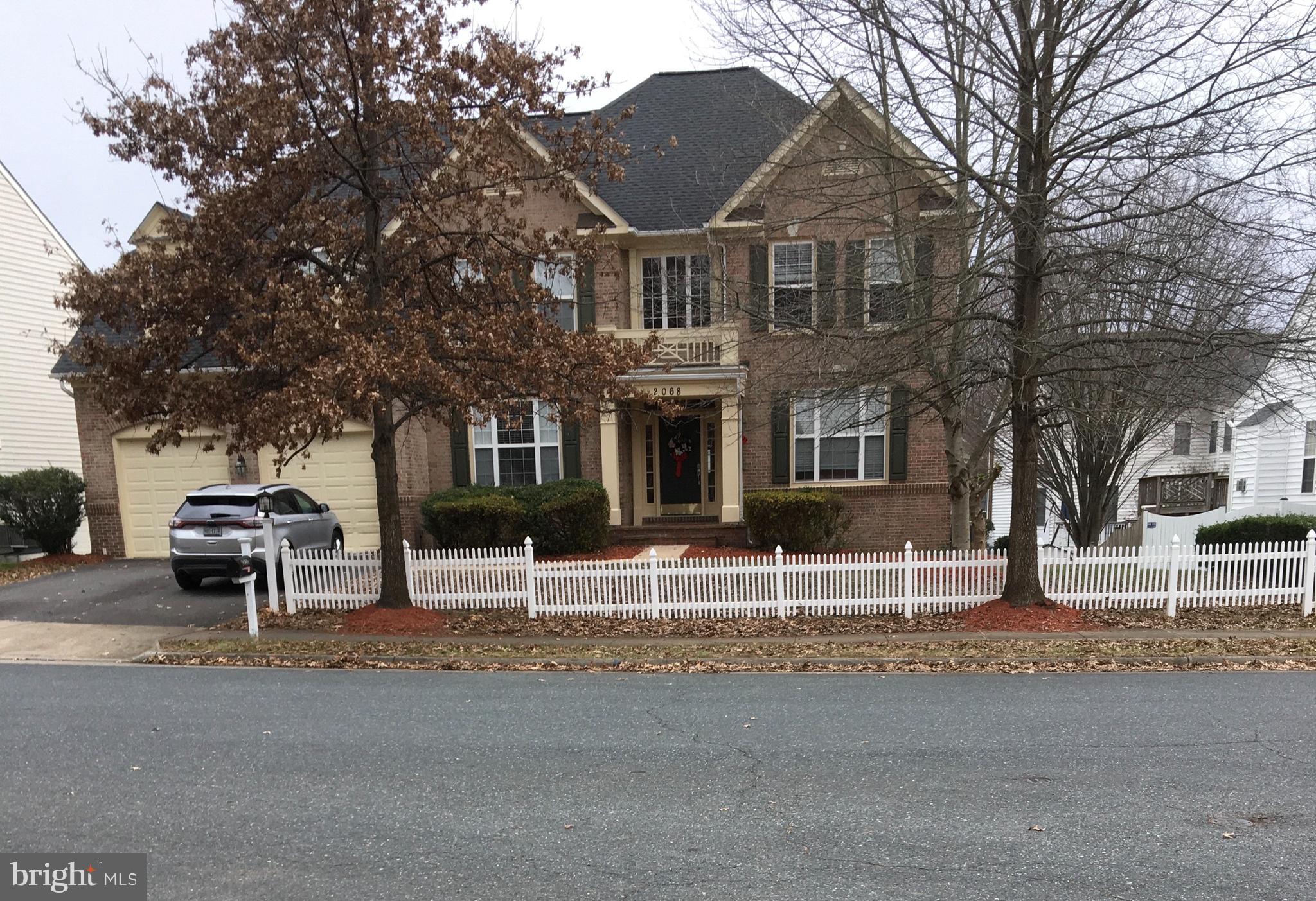 a view of a house with a yard and large tree