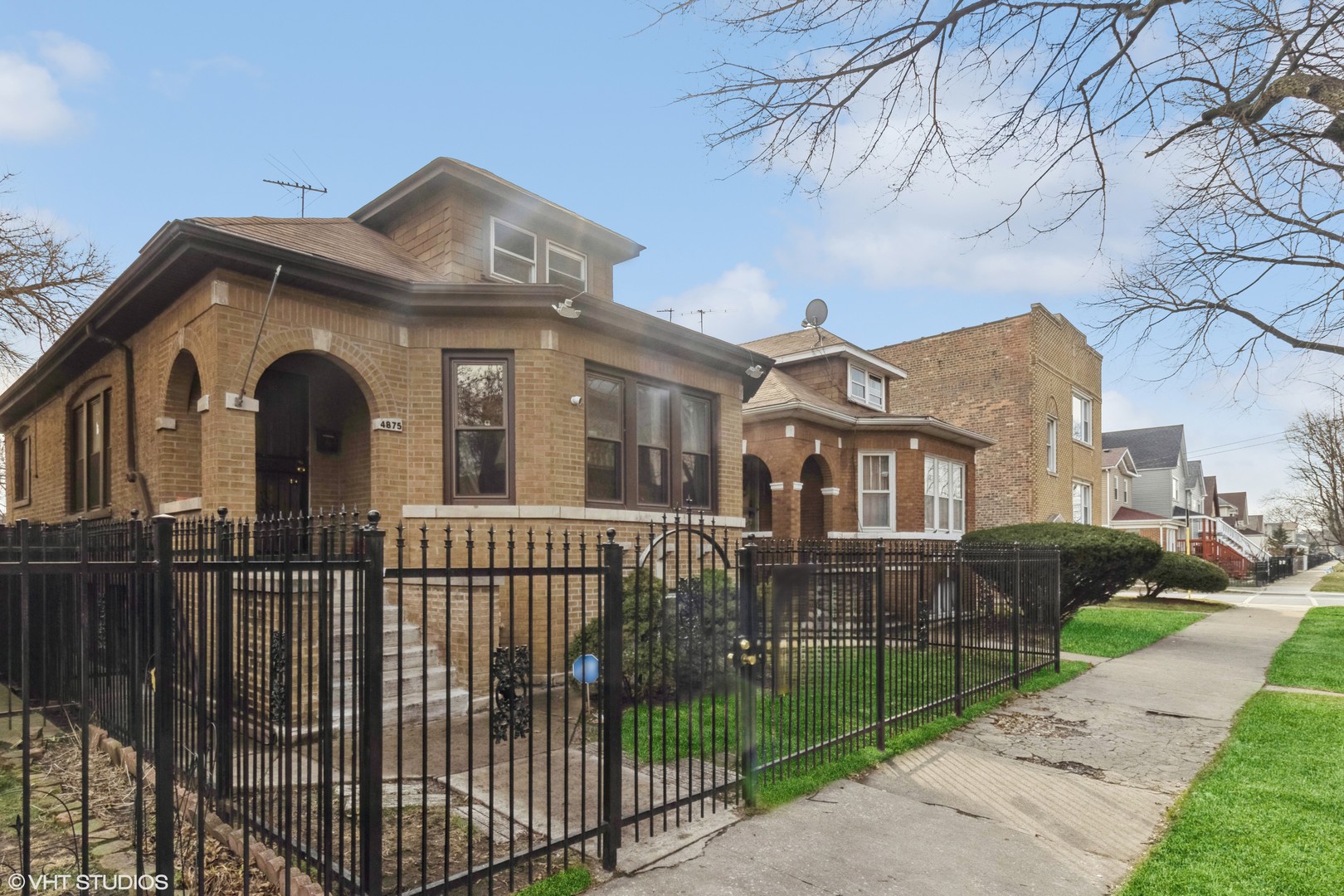 a front view of a house with iron fence