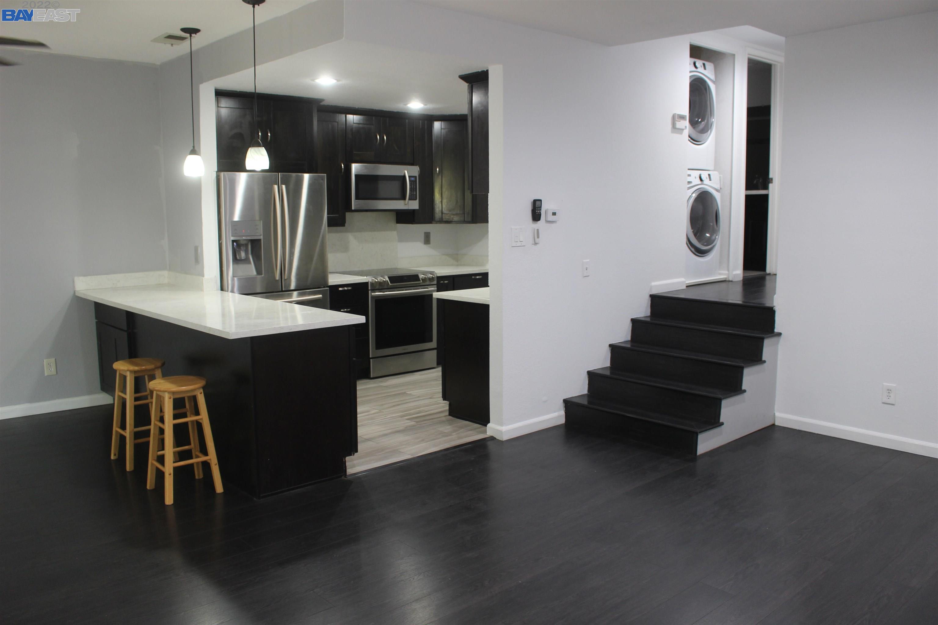 a kitchen with stainless steel appliances kitchen island a refrigerator and a sink