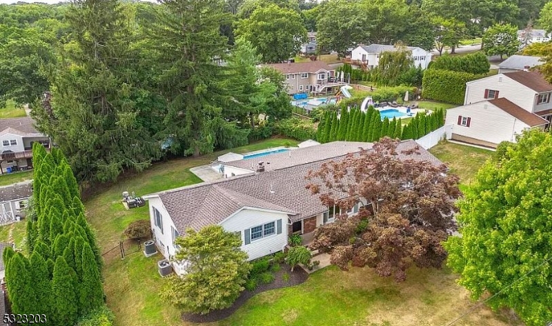 an aerial view of a house with a garden and trees