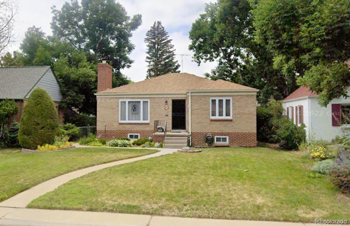 a front view of a house with a yard and trees