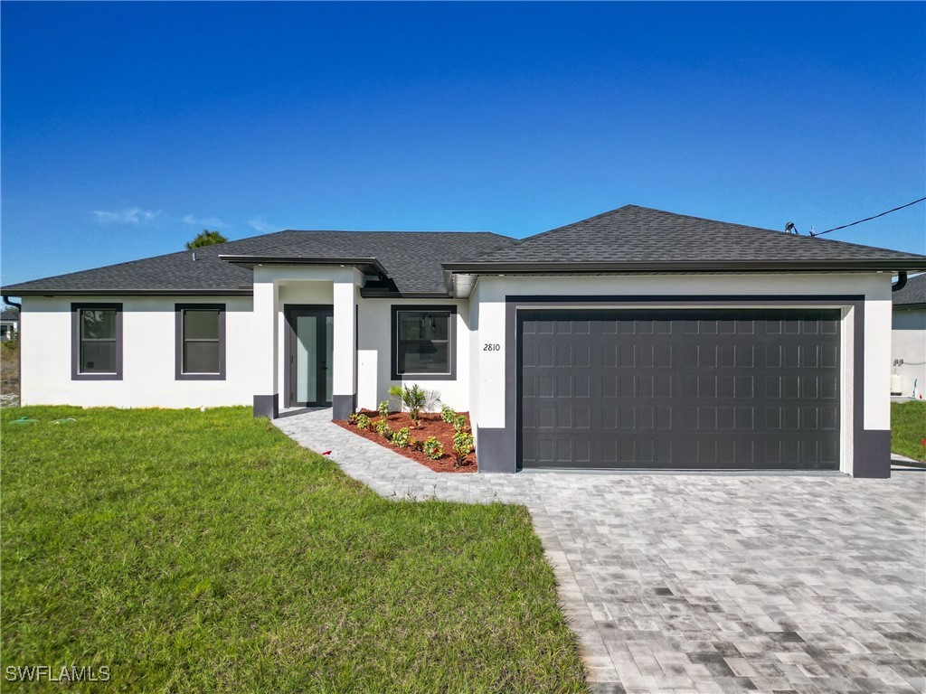 a front view of a house with yard and green space