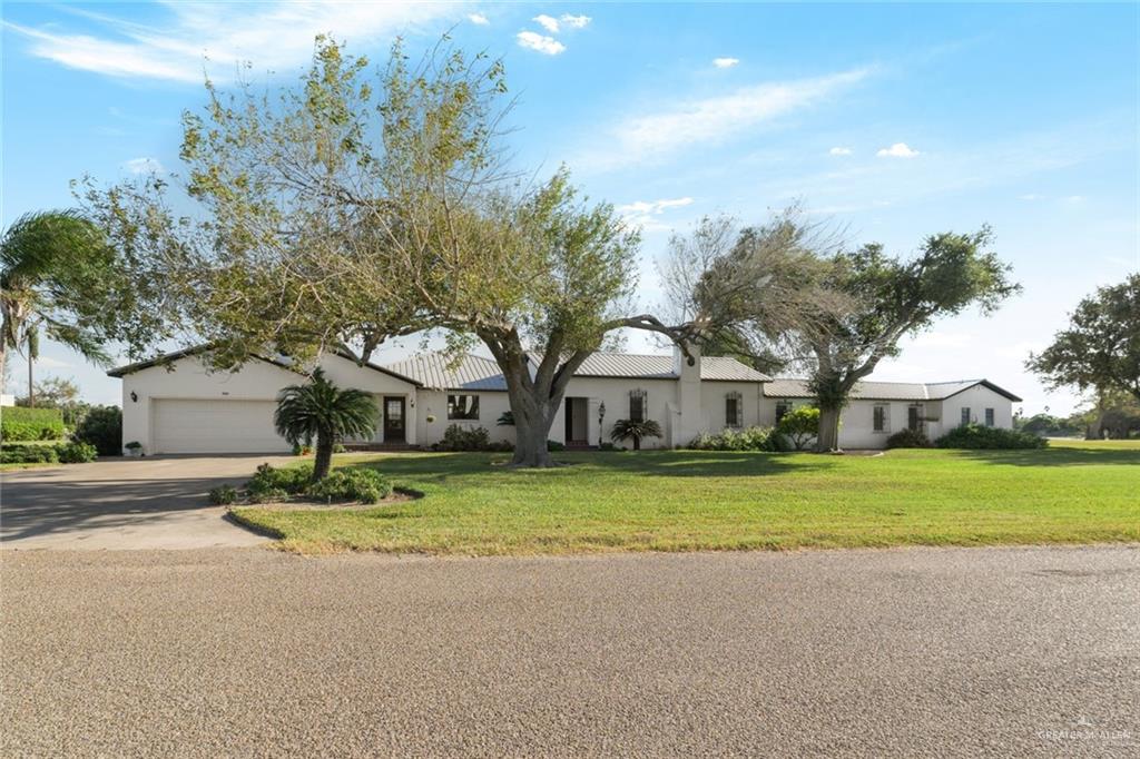 a front view of a house with a garden and trees