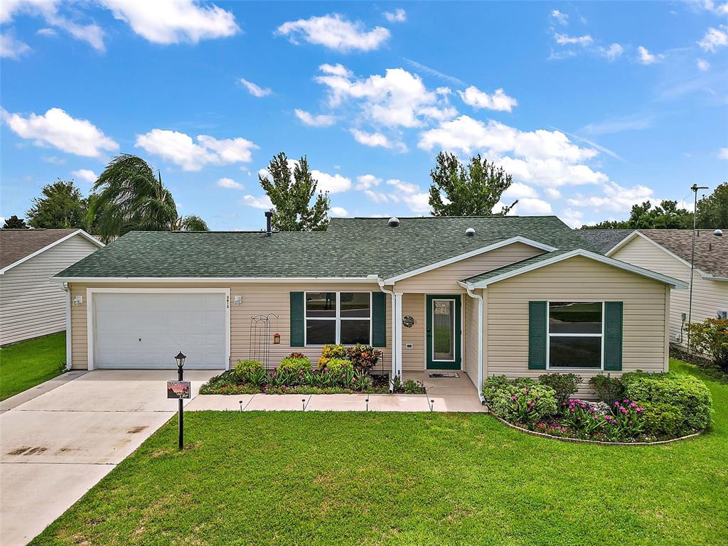 a front view of a house with a garden and yard