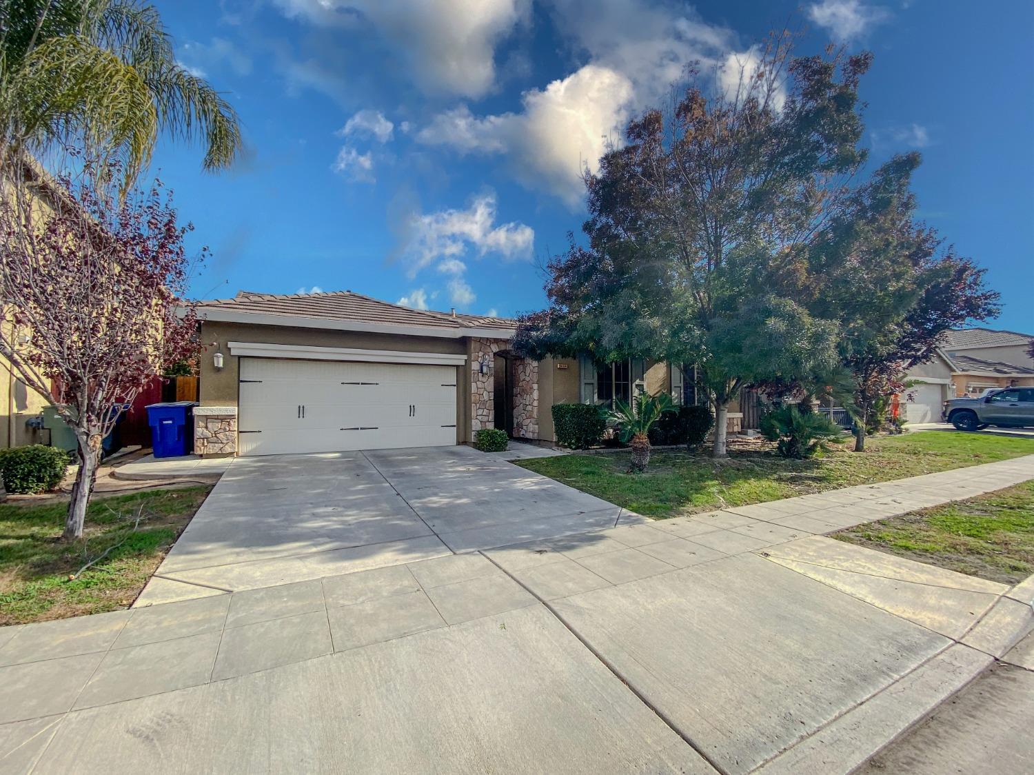 a view of a house with a yard and a garage