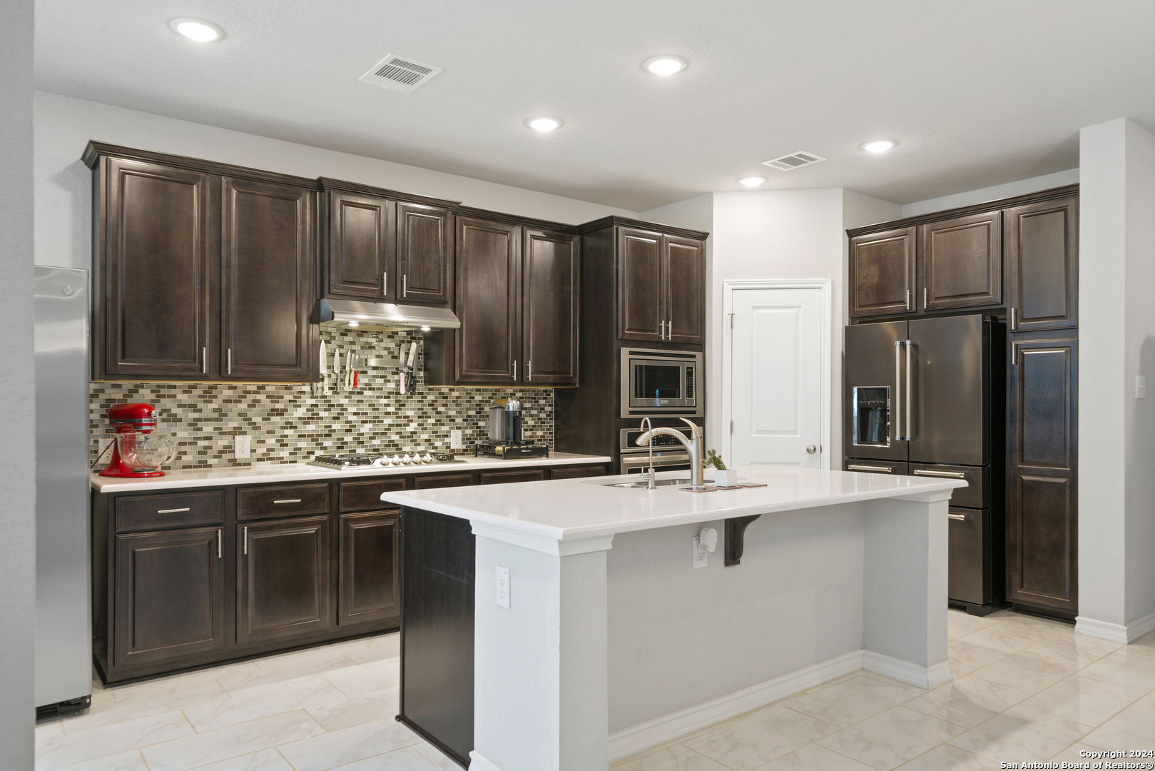 a kitchen with stainless steel appliances granite countertop a sink stove and refrigerator