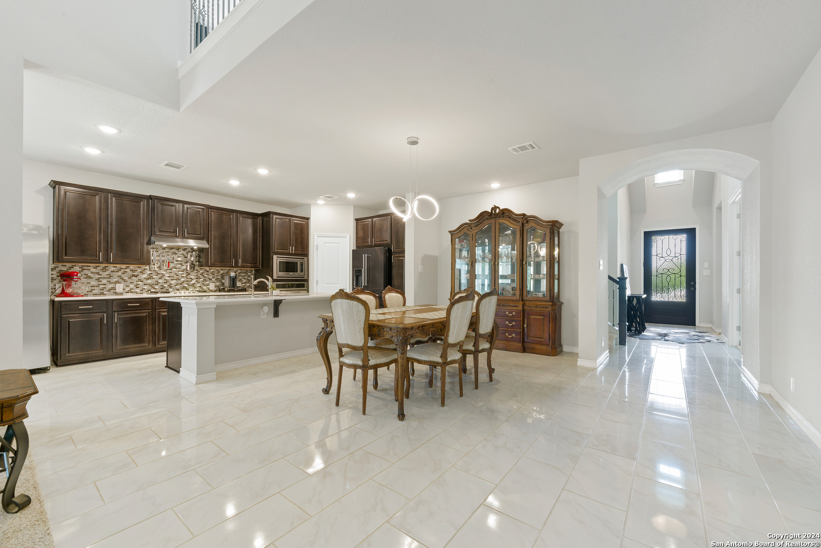 a large white kitchen with lots of white furniture and appliances