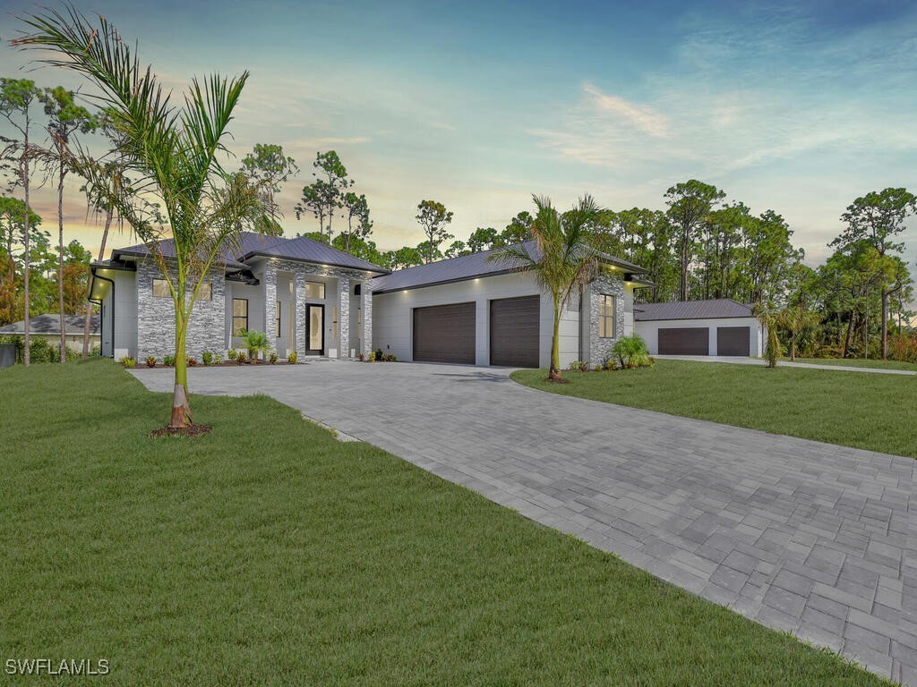 a front view of a house with a yard and trees