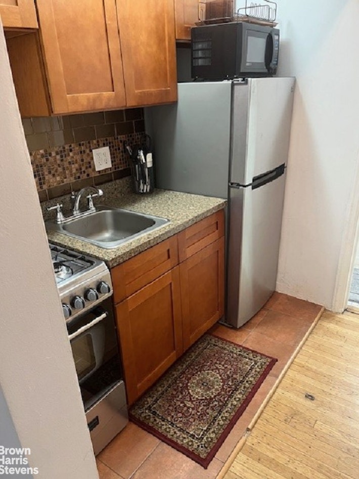 a kitchen with a stove a refrigerator and a sink