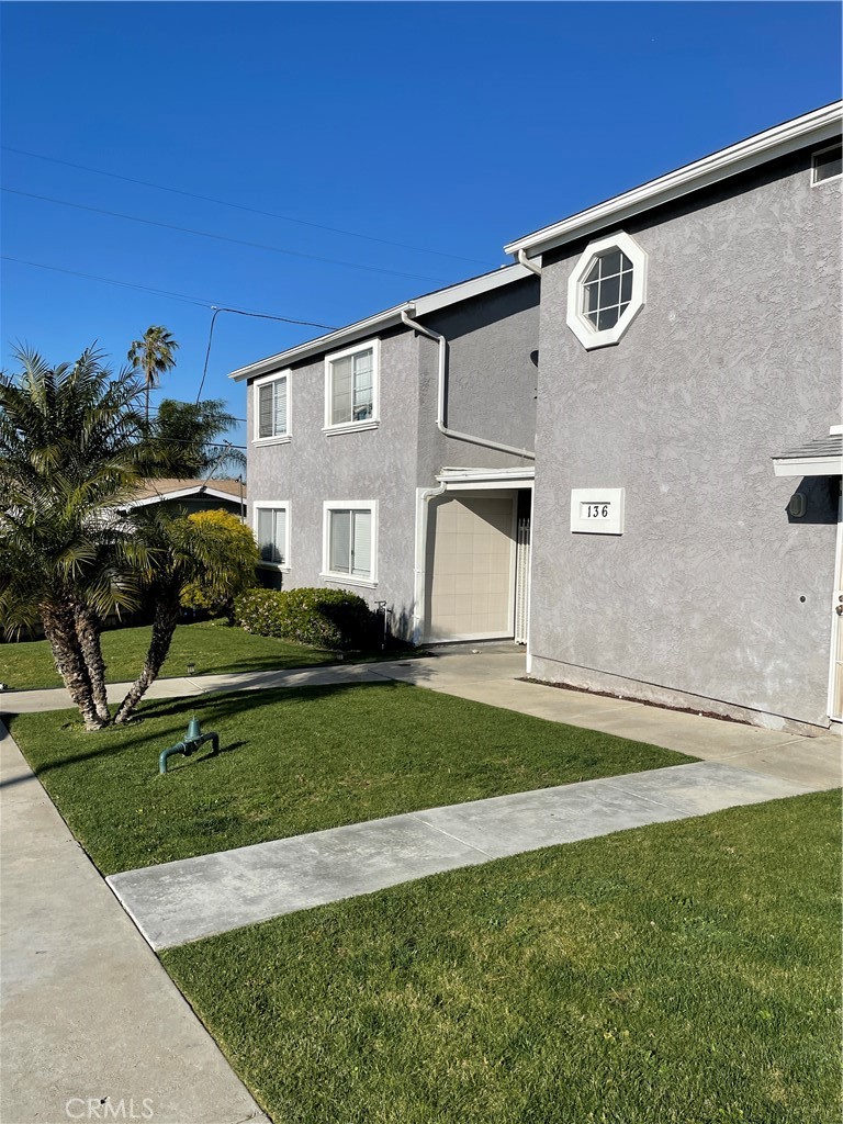 a front view of a house with a garden and yard