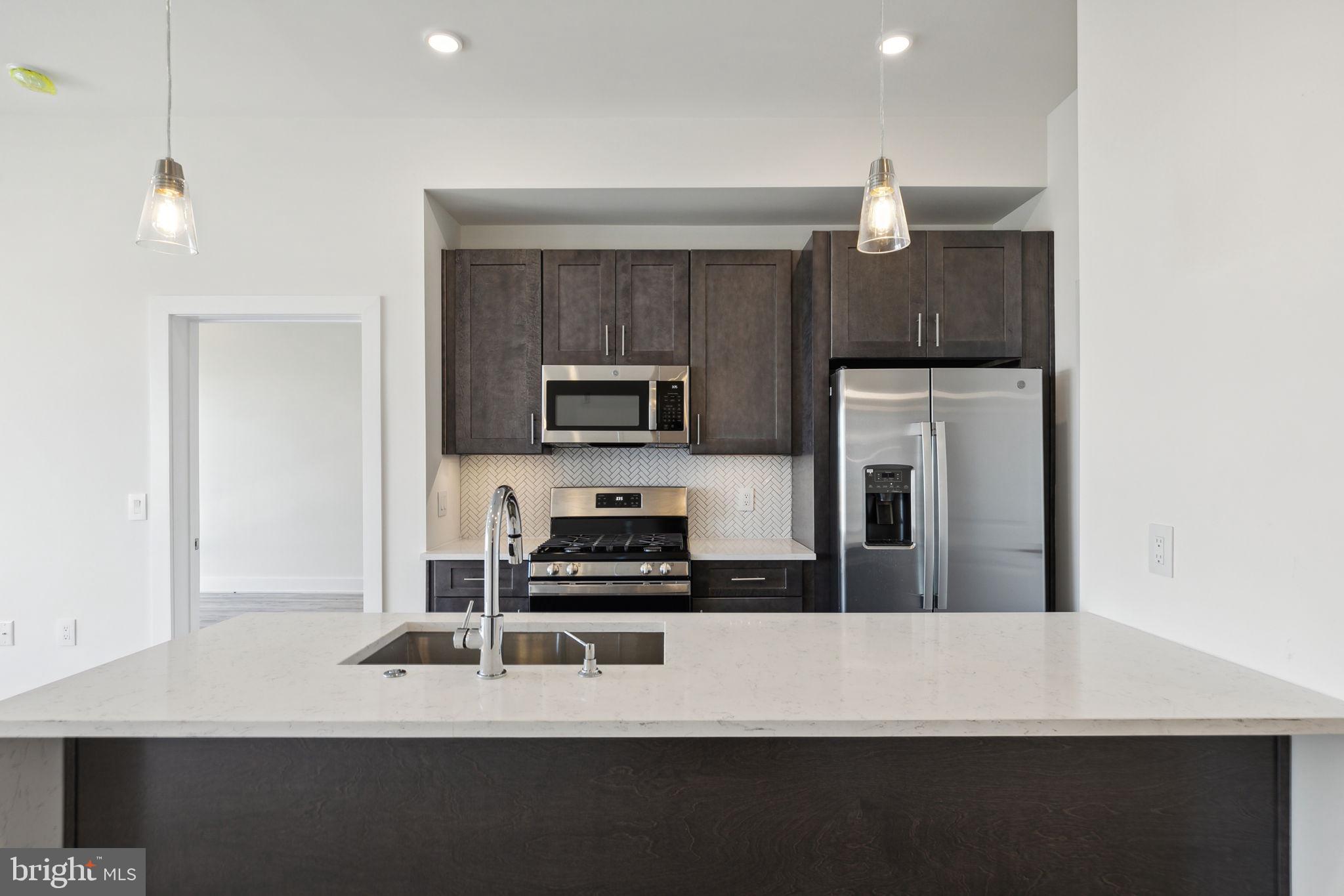 a kitchen with a refrigerator and a stove top oven