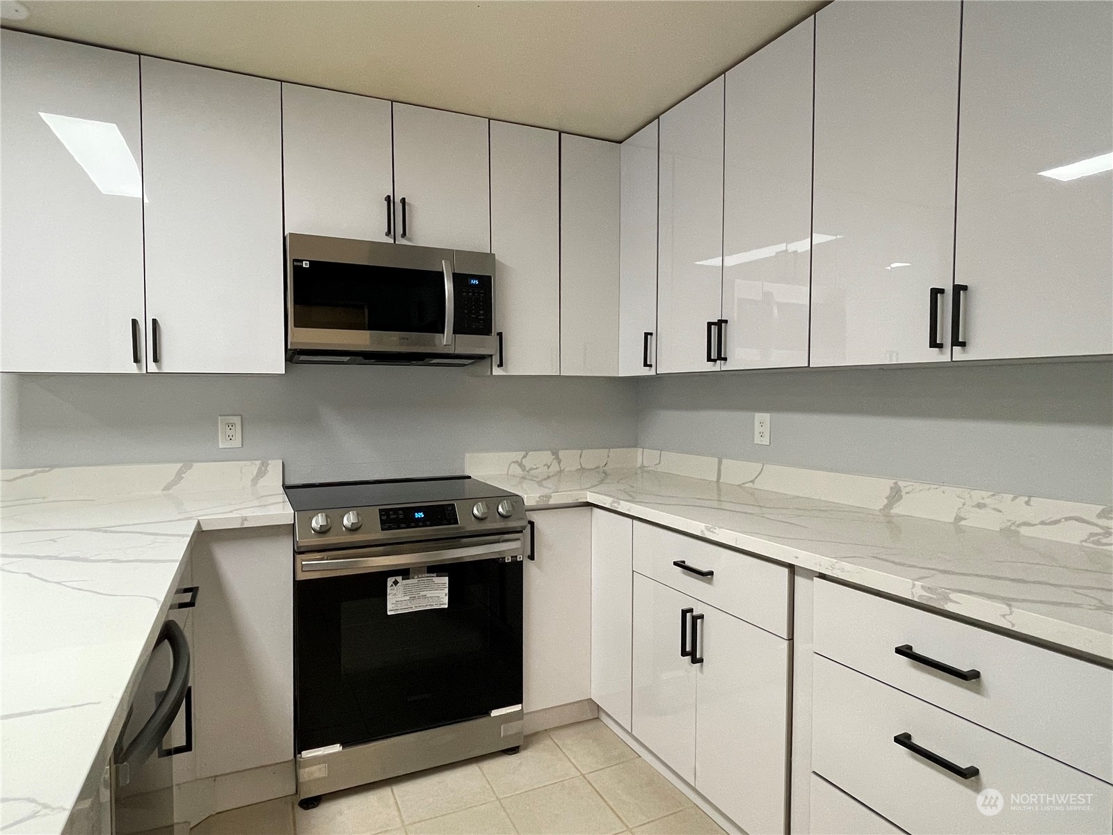 a kitchen with granite countertop white cabinets and stainless steel appliances